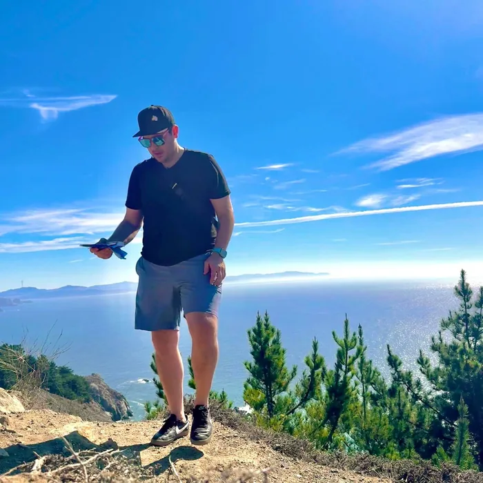 Ben standing on a coastal cliff high above the ocean